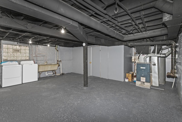 basement featuring washing machine and clothes dryer and sink