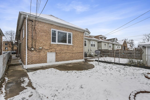 snow covered house featuring cooling unit