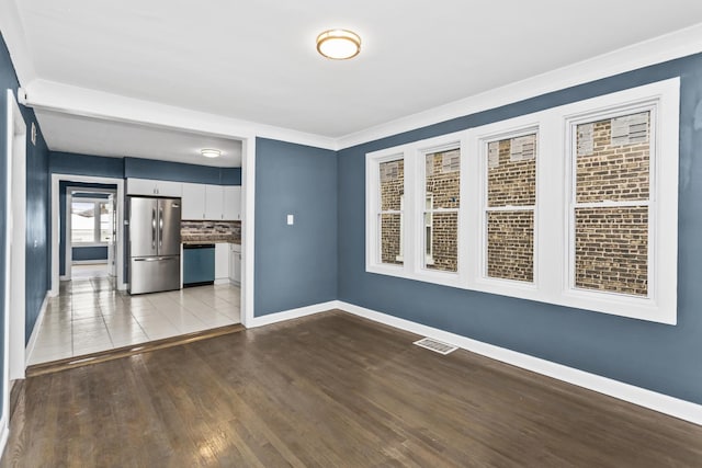 unfurnished room featuring light hardwood / wood-style floors and crown molding