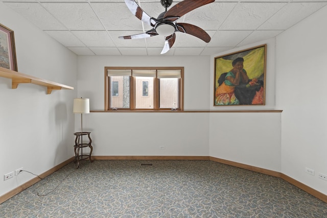 spare room with ceiling fan and a drop ceiling