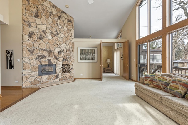 living room with a high ceiling and a stone fireplace