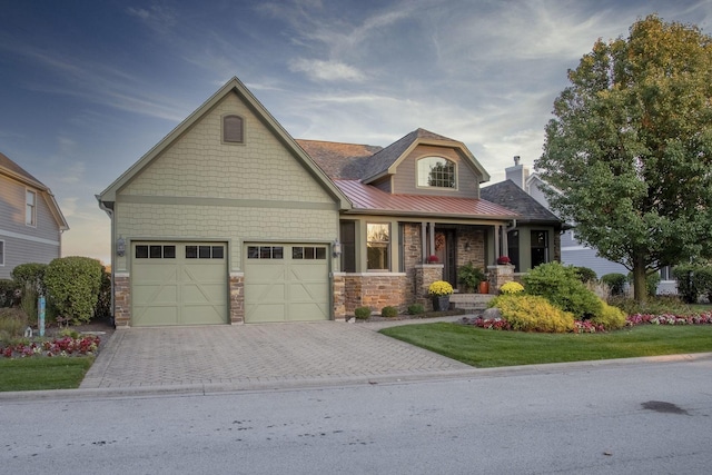 craftsman inspired home with a garage and a front lawn