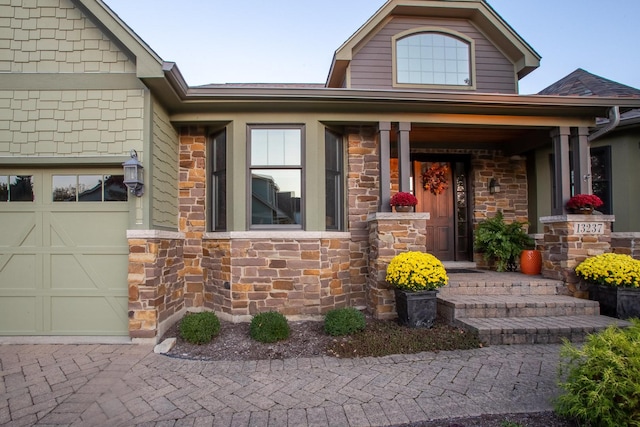 doorway to property featuring a porch and a garage