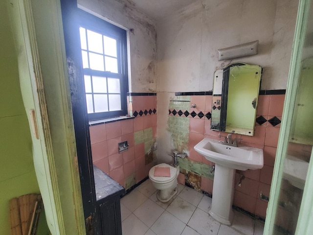 bathroom featuring toilet, tile walls, and tile patterned floors