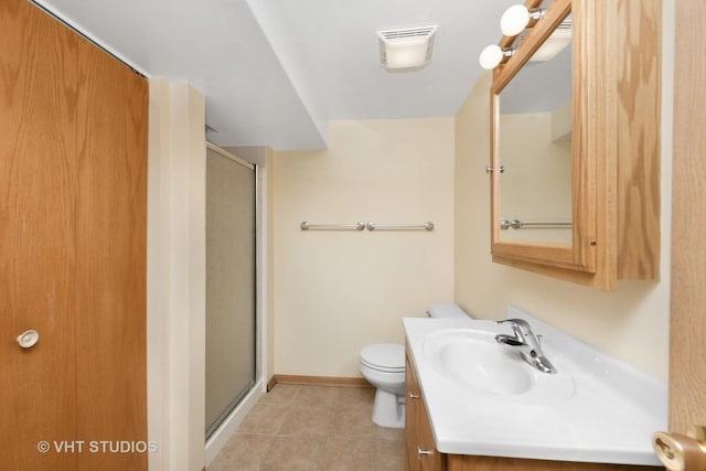 bathroom with tile patterned flooring, vanity, toilet, and a shower with door