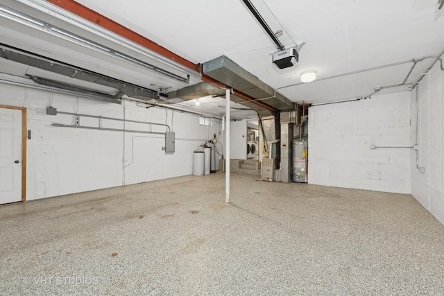 garage featuring electric panel, a garage door opener, heating unit, and water heater