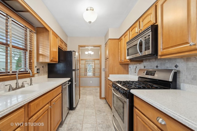 kitchen with a wealth of natural light, a chandelier, sink, and stainless steel appliances