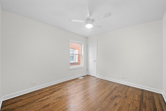 empty room with ceiling fan and dark hardwood / wood-style floors