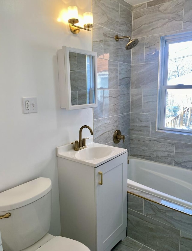 full bathroom with toilet, vanity, and tiled shower / bath combo