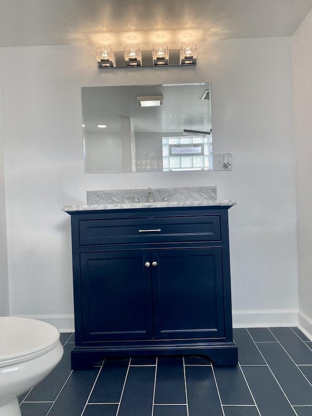 bathroom featuring tile patterned flooring, vanity, and toilet