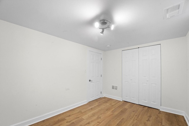 unfurnished bedroom with light hardwood / wood-style flooring and a closet