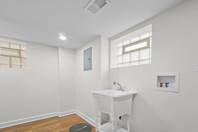 laundry room with electric panel, hardwood / wood-style floors, and washer hookup