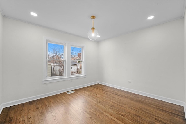 spare room featuring wood-type flooring and ornamental molding