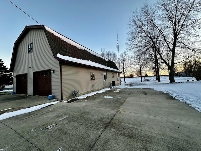 snow covered property with a garage