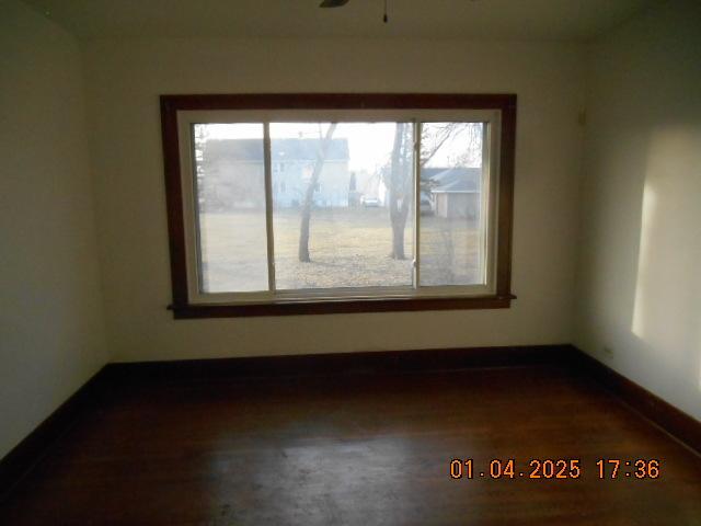 unfurnished room featuring ceiling fan, a healthy amount of sunlight, and dark hardwood / wood-style floors