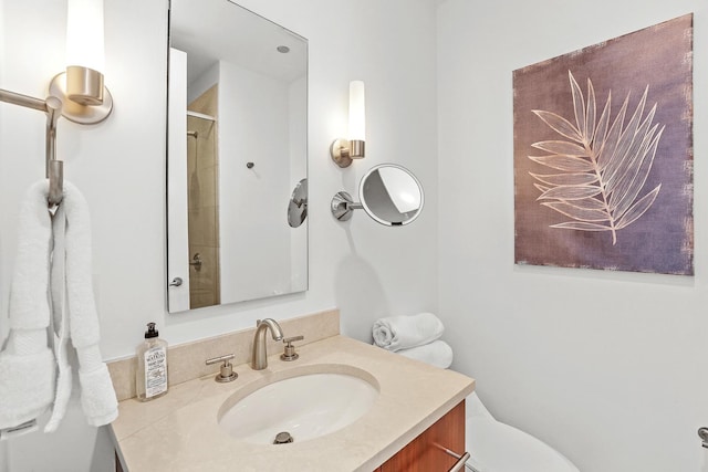 bathroom with a shower, vanity, and toilet