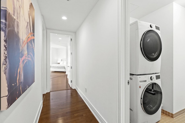 laundry area with hardwood / wood-style floors and stacked washer / drying machine