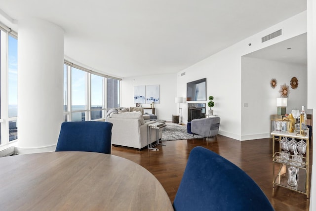 living room with dark hardwood / wood-style flooring and a water view