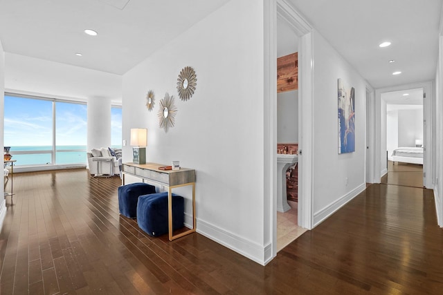 hallway featuring dark hardwood / wood-style flooring and a water view