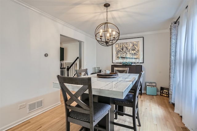 dining area featuring a chandelier, light hardwood / wood-style flooring, and crown molding