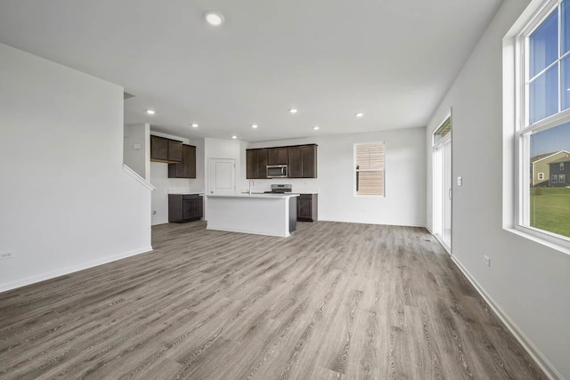 unfurnished living room with hardwood / wood-style floors and sink