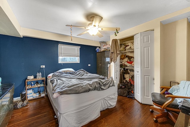 bedroom with dark wood-type flooring, ceiling fan, and a closet