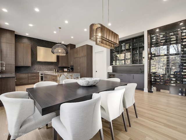 dining space with plenty of natural light, light hardwood / wood-style floors, and sink