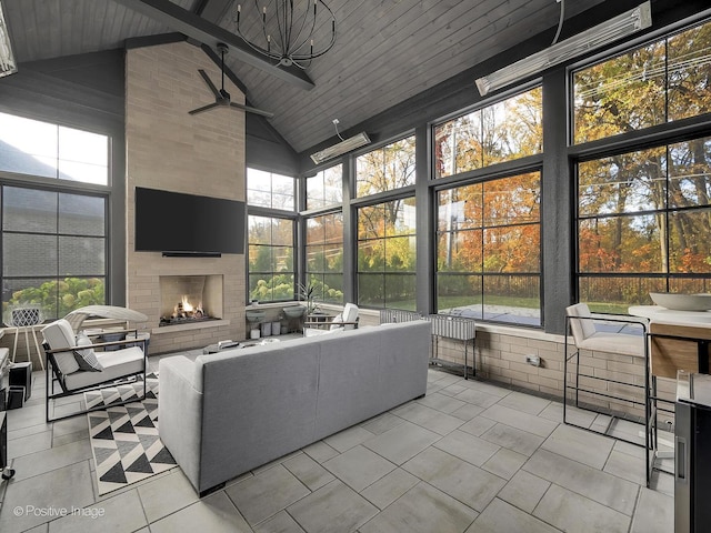 sunroom / solarium with wooden ceiling, a large fireplace, and lofted ceiling with beams