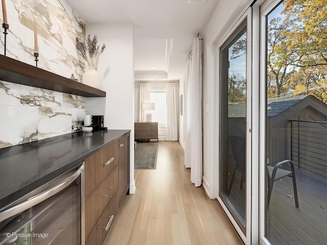 kitchen featuring plenty of natural light, light wood-type flooring, and beverage cooler