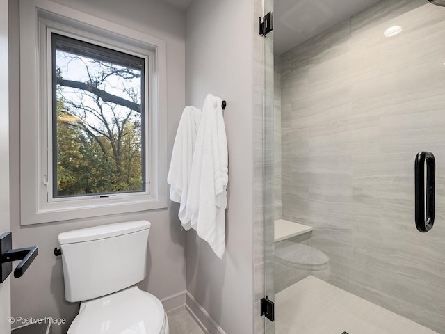 bathroom featuring toilet and a shower with shower door