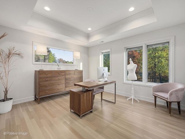 home office featuring light wood-type flooring, a tray ceiling, plenty of natural light, and crown molding