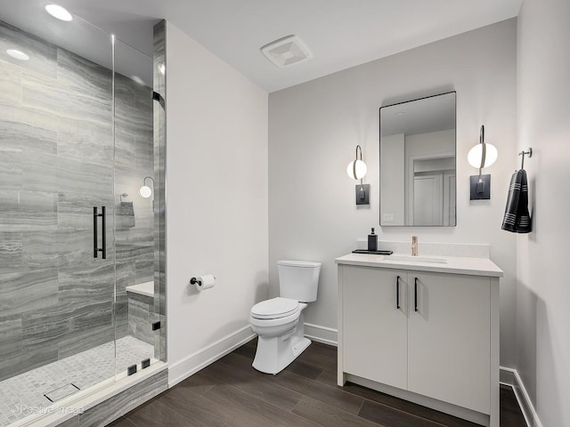 bathroom featuring vanity, toilet, and a shower with door