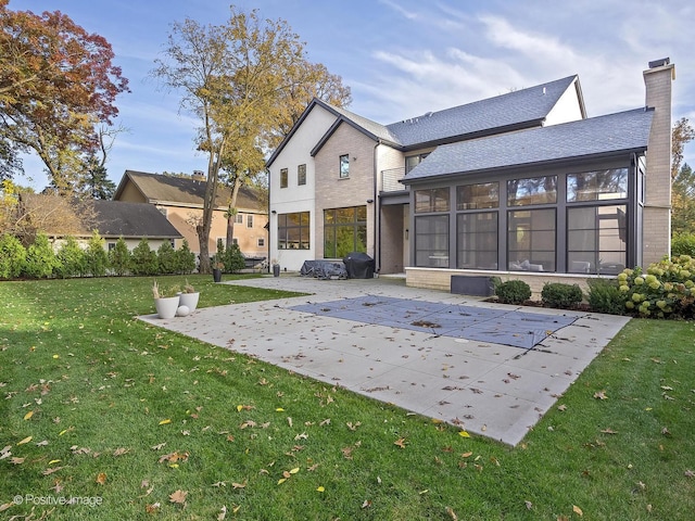 back of house with a lawn, a patio area, a sunroom, and a covered pool