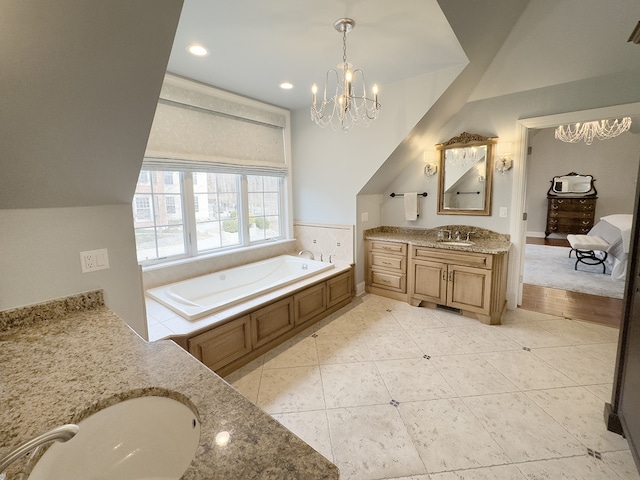 bathroom with tile patterned floors, a tub to relax in, vanity, and an inviting chandelier