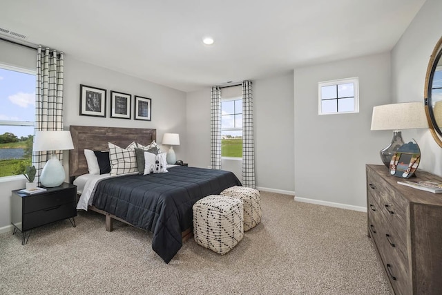 bedroom featuring light carpet and multiple windows