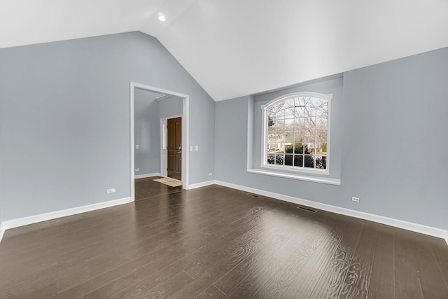 empty room with dark hardwood / wood-style flooring and lofted ceiling