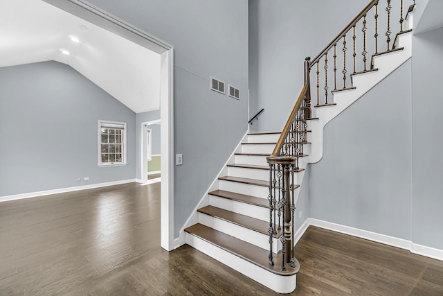 stairs with vaulted ceiling and wood-type flooring