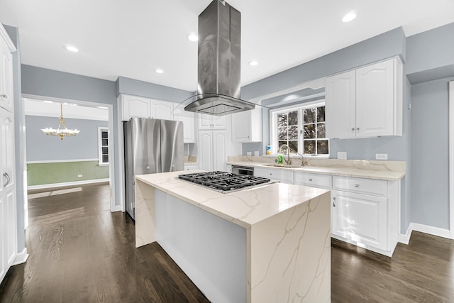 kitchen with white cabinetry, island exhaust hood, light stone counters, a center island, and stainless steel appliances