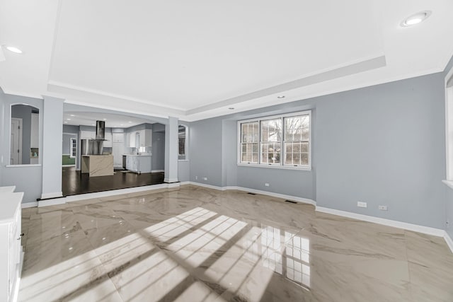 unfurnished living room with a raised ceiling