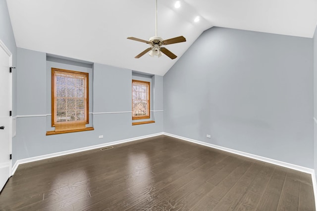 spare room with dark wood-type flooring, vaulted ceiling, and ceiling fan