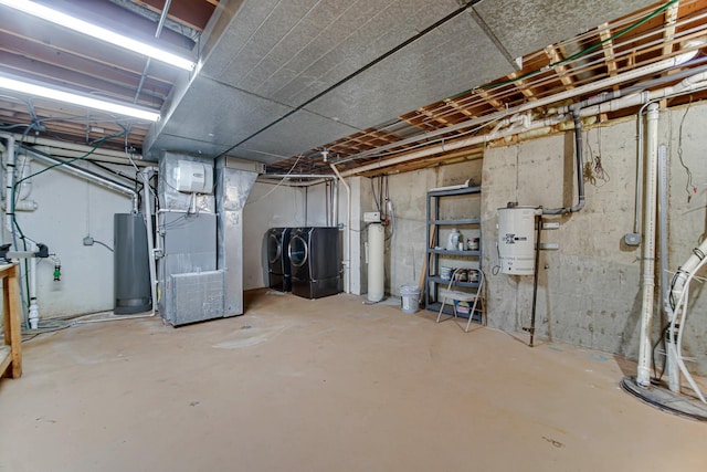 basement with heating unit, water heater, and washing machine and clothes dryer