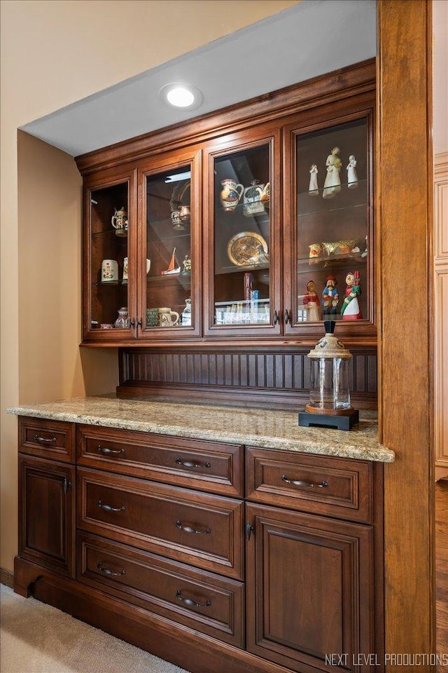 bar featuring carpet and light stone counters