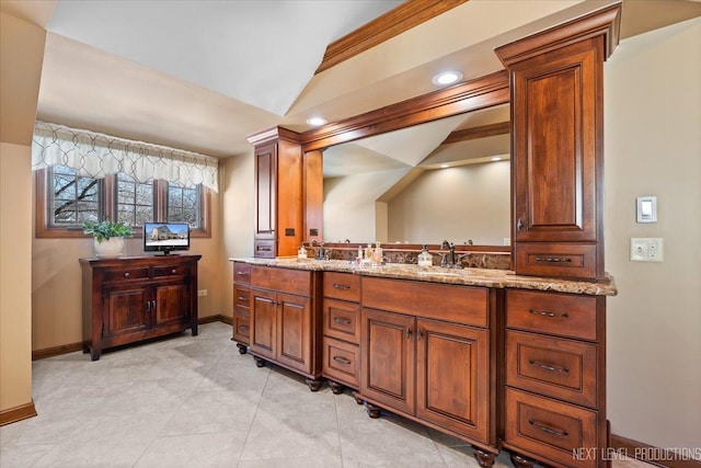 bathroom with vanity, vaulted ceiling, and ornamental molding