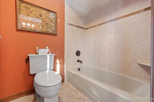 bathroom featuring tile patterned floors, tiled shower / bath combo, and toilet