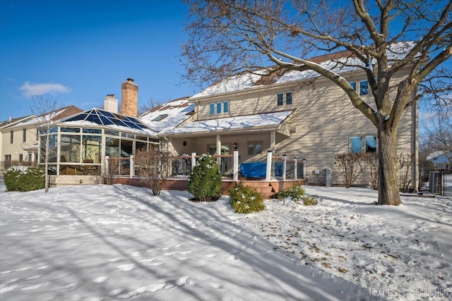 snow covered property featuring a sunroom