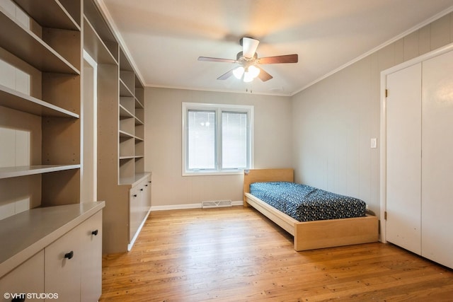 bedroom featuring ceiling fan, light wood-type flooring, and crown molding