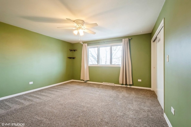 empty room with ceiling fan and carpet floors