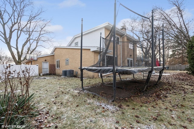 back of property featuring a trampoline and central AC