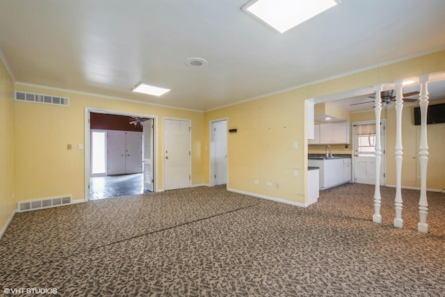 carpeted empty room with crown molding and sink