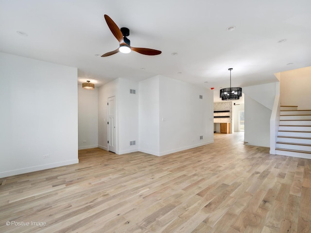 unfurnished living room featuring ceiling fan and light wood-type flooring